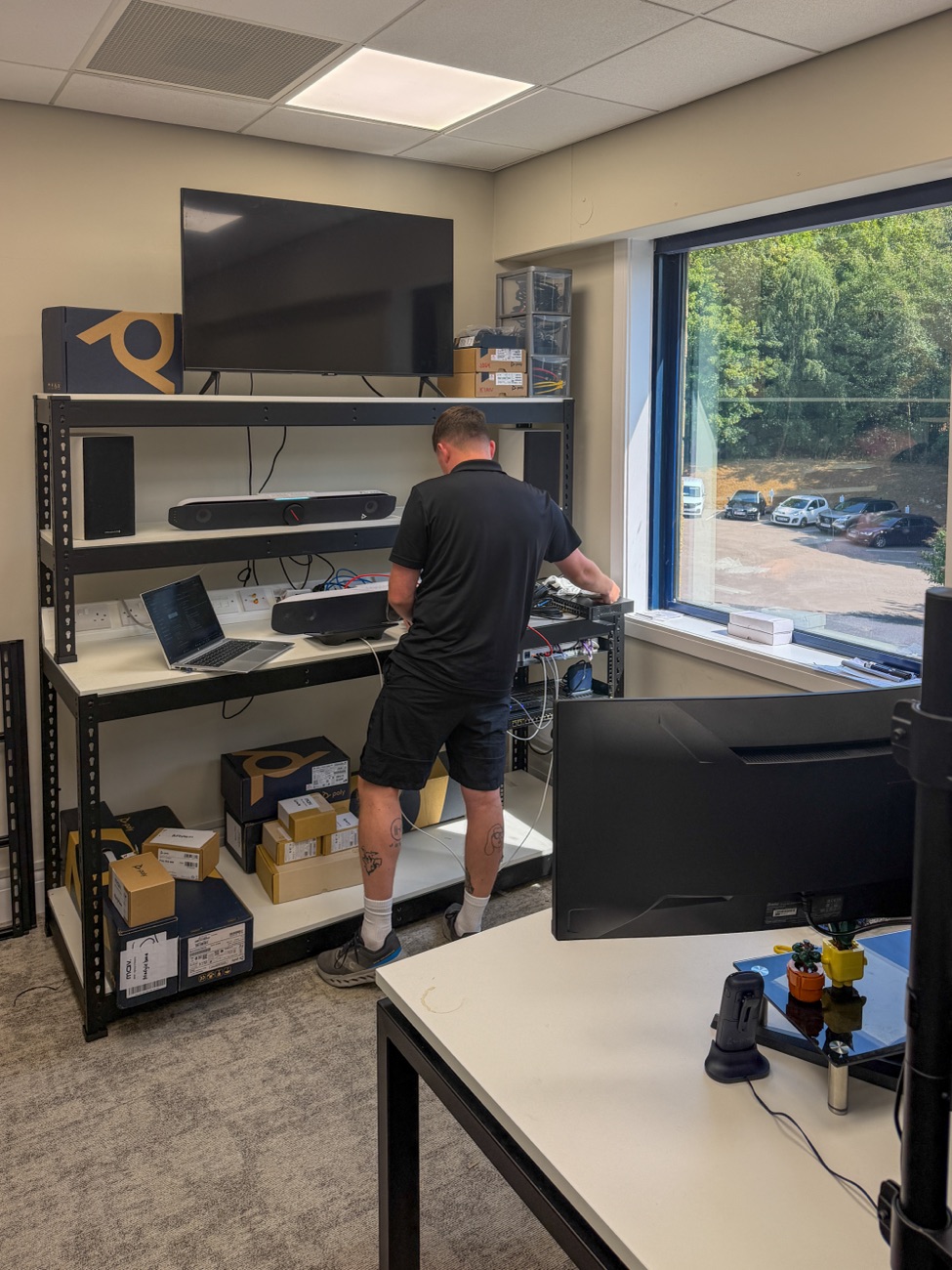 MAV engineer testing video conferencing endpoints and network kit on the staging bench in our office
