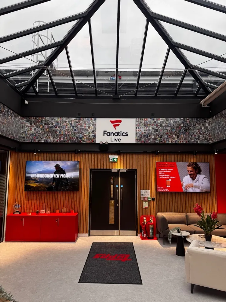 Reception atrium with a glazed roof, digital signage displays and collector-card wall graphics