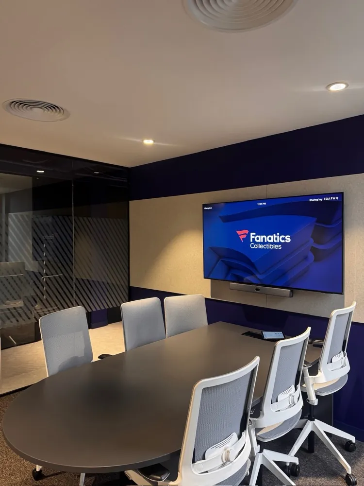 Six-seat meeting room with wall display, video bar and a glass partition wall
